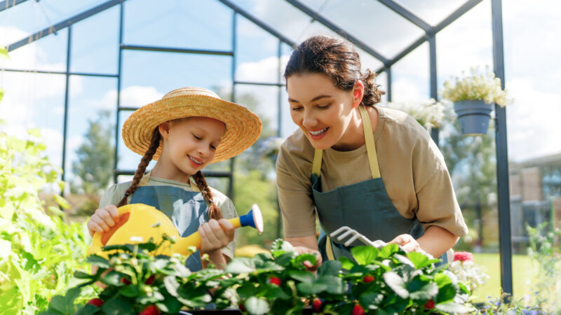 Mother and daughter in a greenhouse with greenhouse climate battery